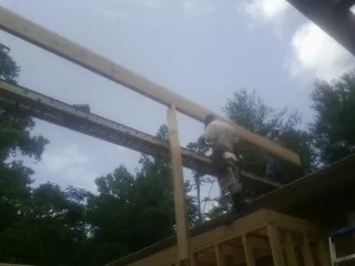 Carpenter setting a ridge beam over a new addition frame — Ice Dam Removal by Roofing Brothers in Little Suamico