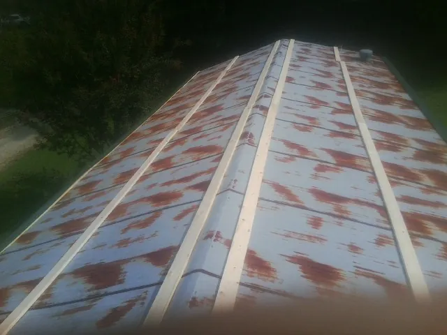 Rusted metal roof panels with new wood purlins before replacement — Storm Damage Roof Repair in Little Suamico by Roofing Brothers