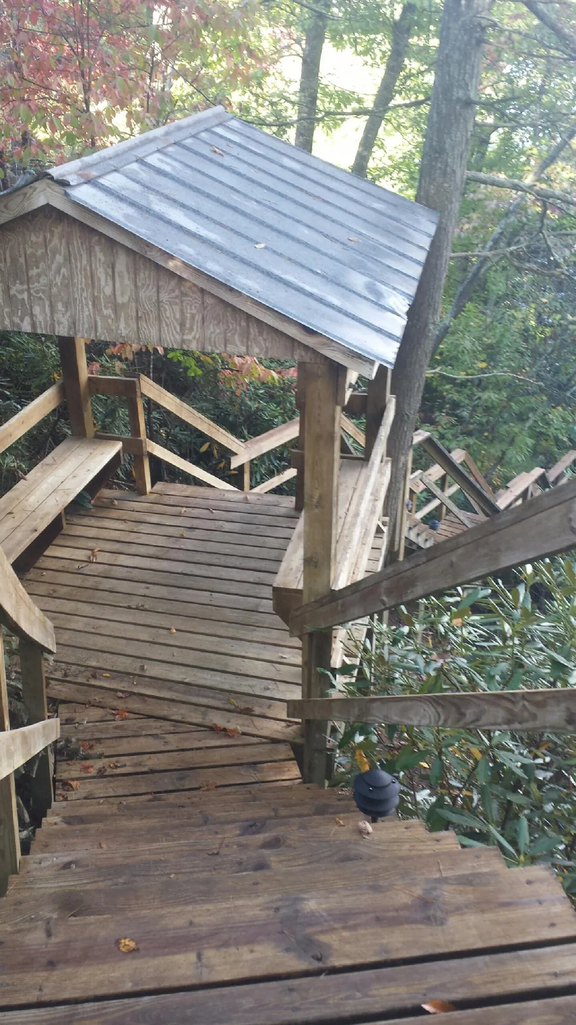 Metal roofed shelter over wooden steps on a wooded walkway — Skylight Repair & Installation work by our crew in Little Suamico