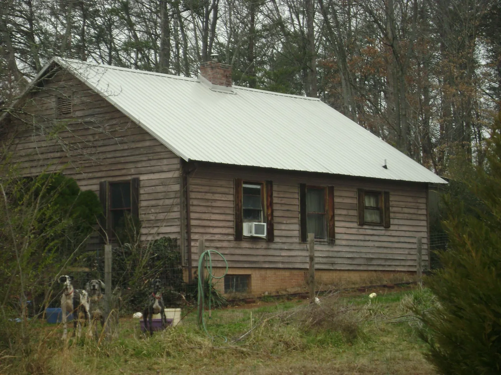 White metal roof on an old wood sided farmhouse, from a Asphalt Shingle Roof Repair job in Little Suamico